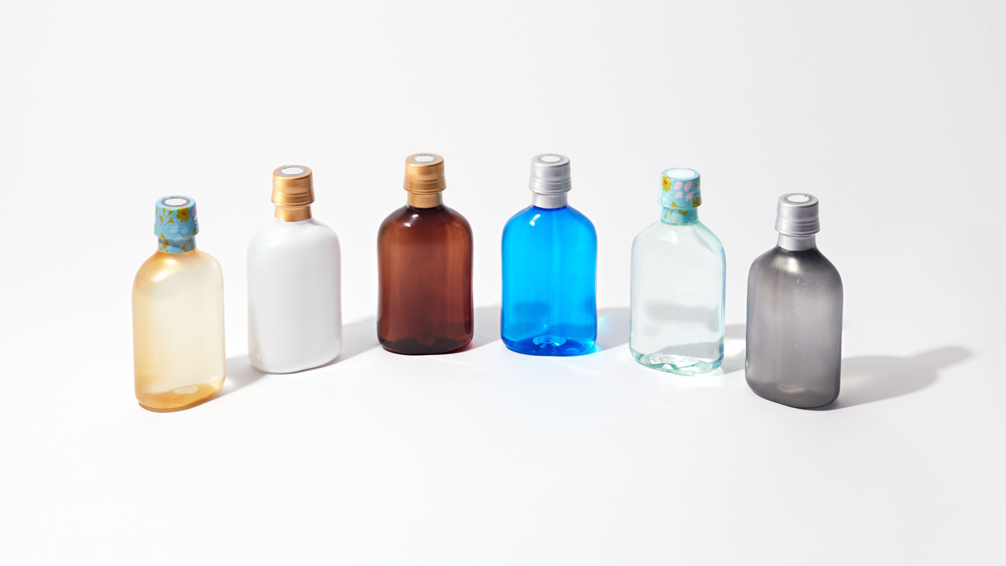 Functional film complex PET Bottles in varied shapes and colors for alcoholic beverages, showcasing high barrier performance and innovative bottle design.