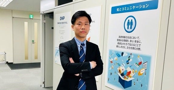 事務所の中で腕を組みをしているTさん