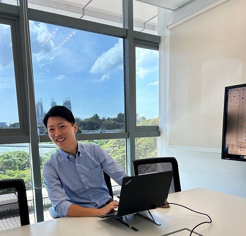 会議室で打ち合わせをしているTさんの写真