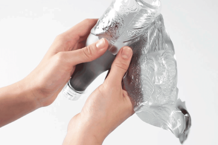 Functional film complex PET Bottle design featuring a peel-away film for easy recycling and high barrier performance.