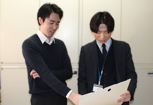 同僚とサンプル品を見ながら打ち合わせをするSさん