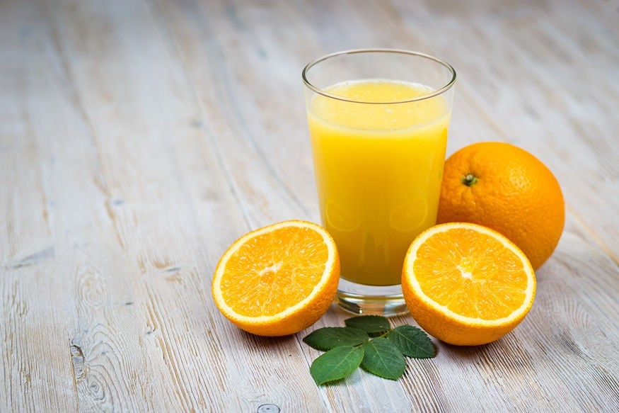Orange juice and citrus fruits on rustic wooden table with copy space
