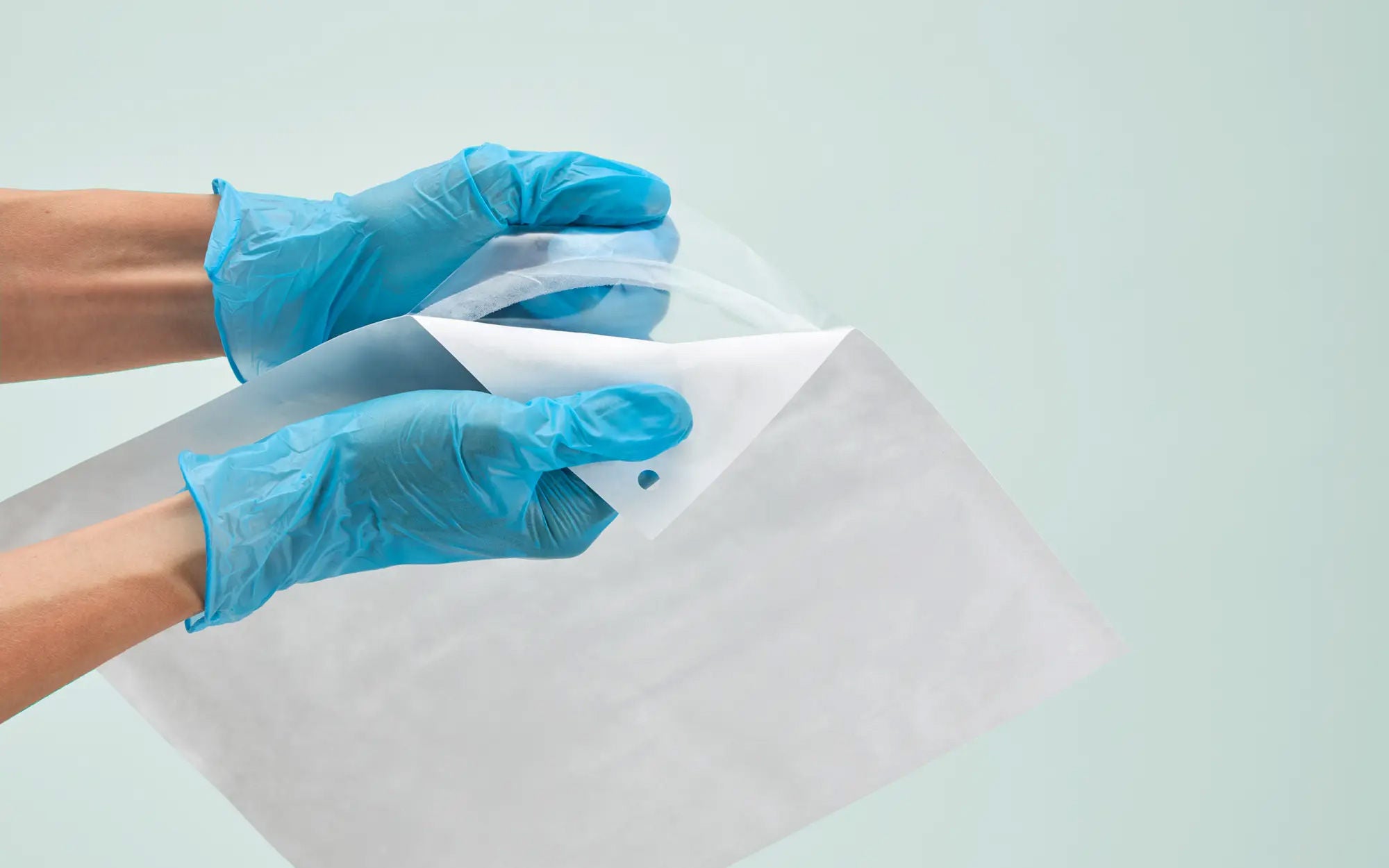 Gloved hands smoothly open a DNP sterilization pouch after medical sterilization