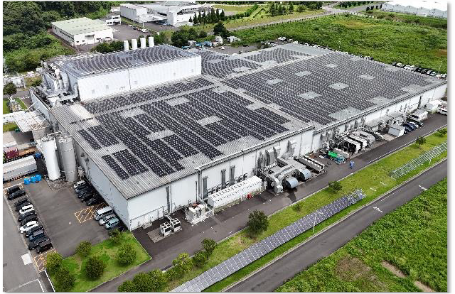 工場建屋の屋根一面に設置された太陽光パネルによる、泉崎工場の太陽光発電設備を上空から撮影した写真