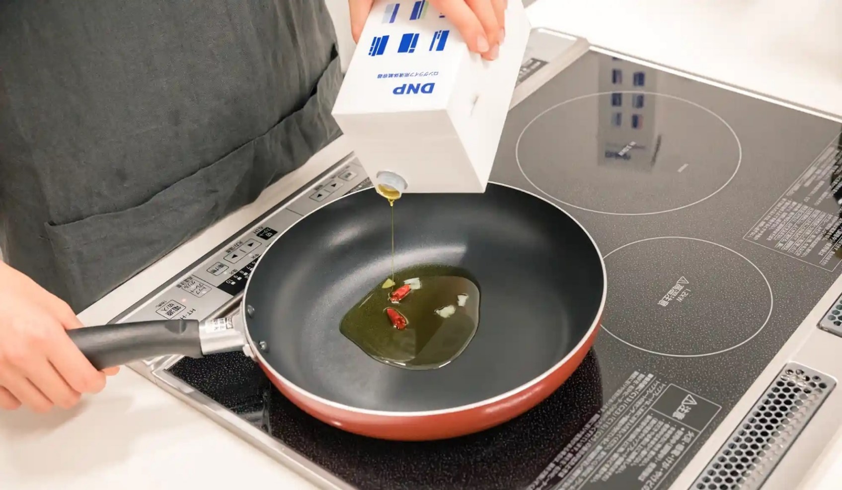 Pouring cooking oil from the liquid packaging carton for long shelf life into a frying pan