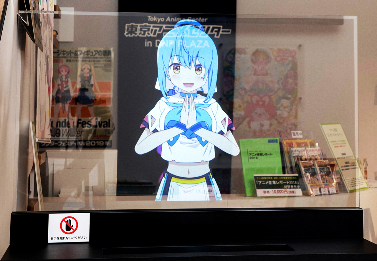 A photo of an animated character projected onto a transparent screen.
